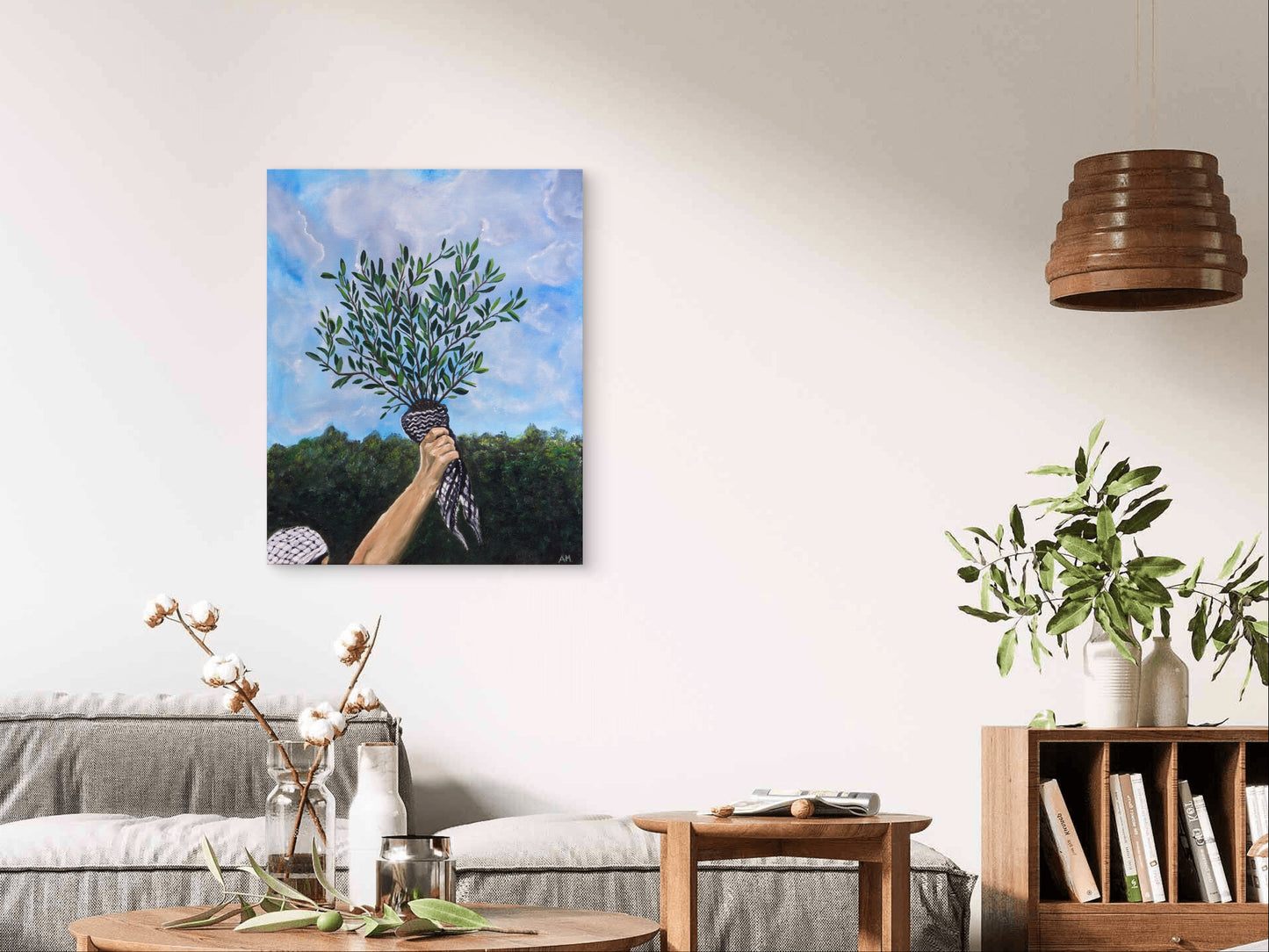 Living room with a gray sofa, wooden coffee table, and a painting of a hand holding flowers on the wall.